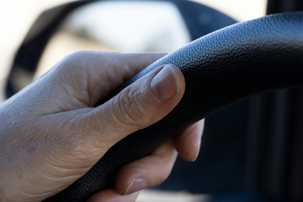 a person holding the steering wheel of a vehicle