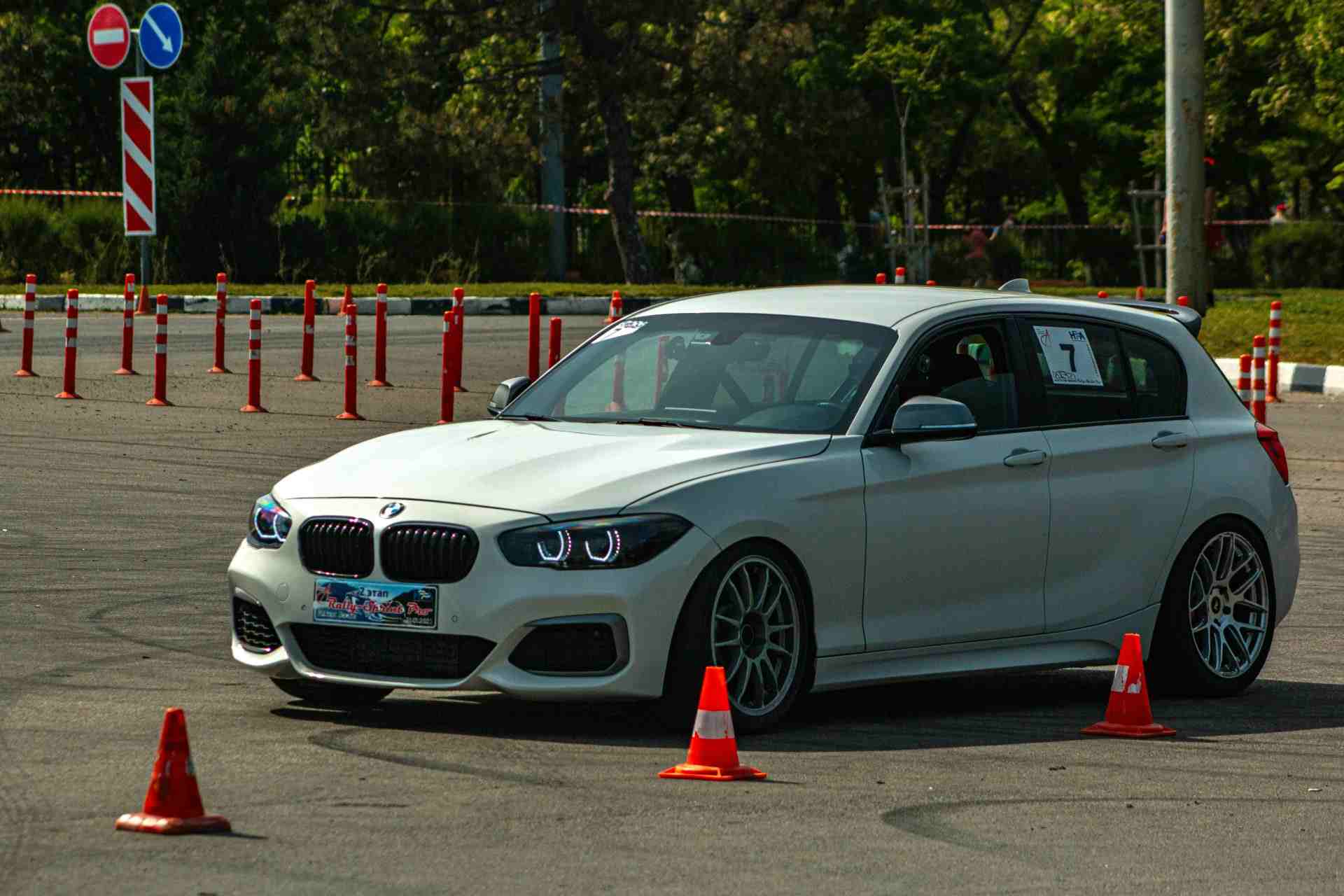 A white BMW is navigating an autocross course.